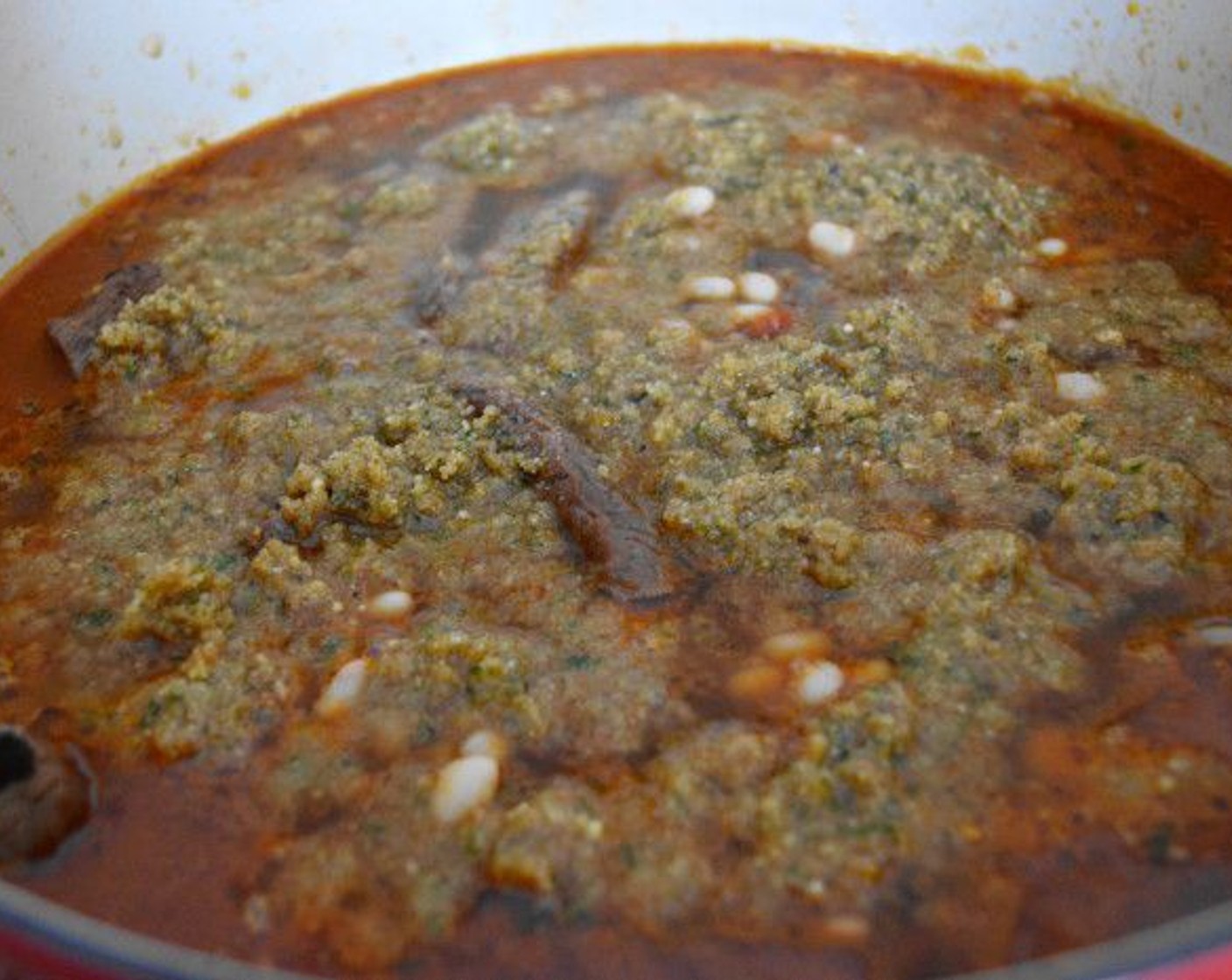 step 15 Assemble the cassoulet by scooping the beans into the bottom of the dutch oven. Pour the beef stew over the beans and add in the cooked sausage and bacon. Give that all a stir, then sprinkle the breadcrumbs on top to absorb into the liquid.