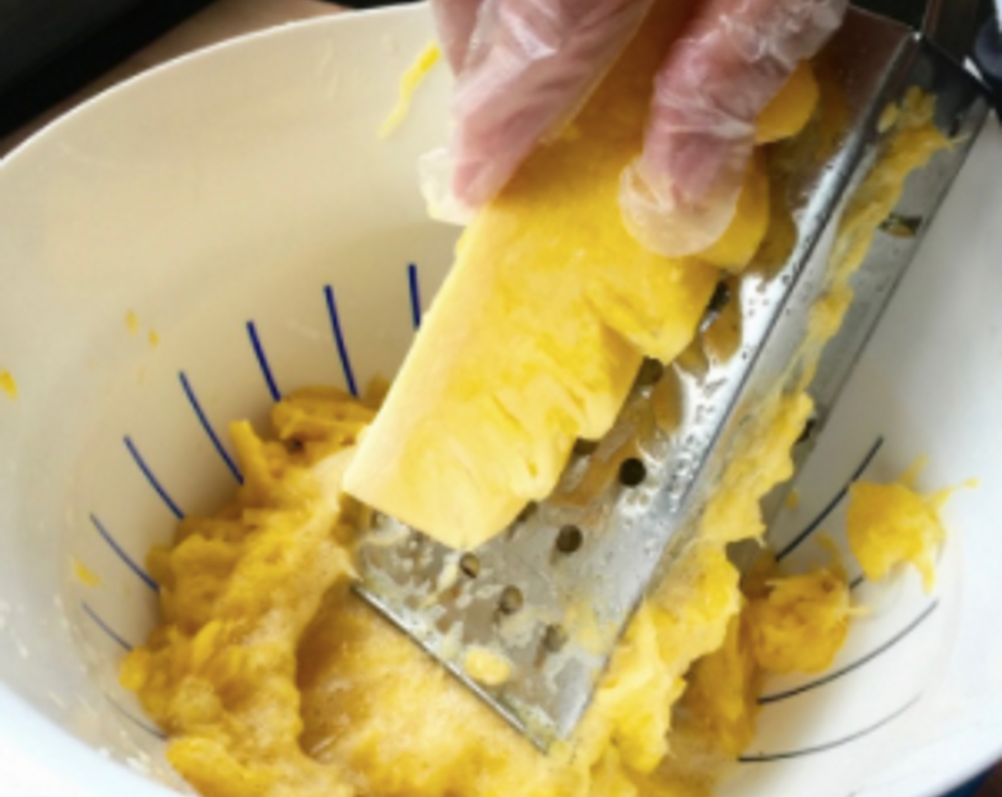 step 10 Grate the pineapple using the largest holes on the box grater and discard the core. It is recommended to wear plastic gloves hand grating the pineapples.