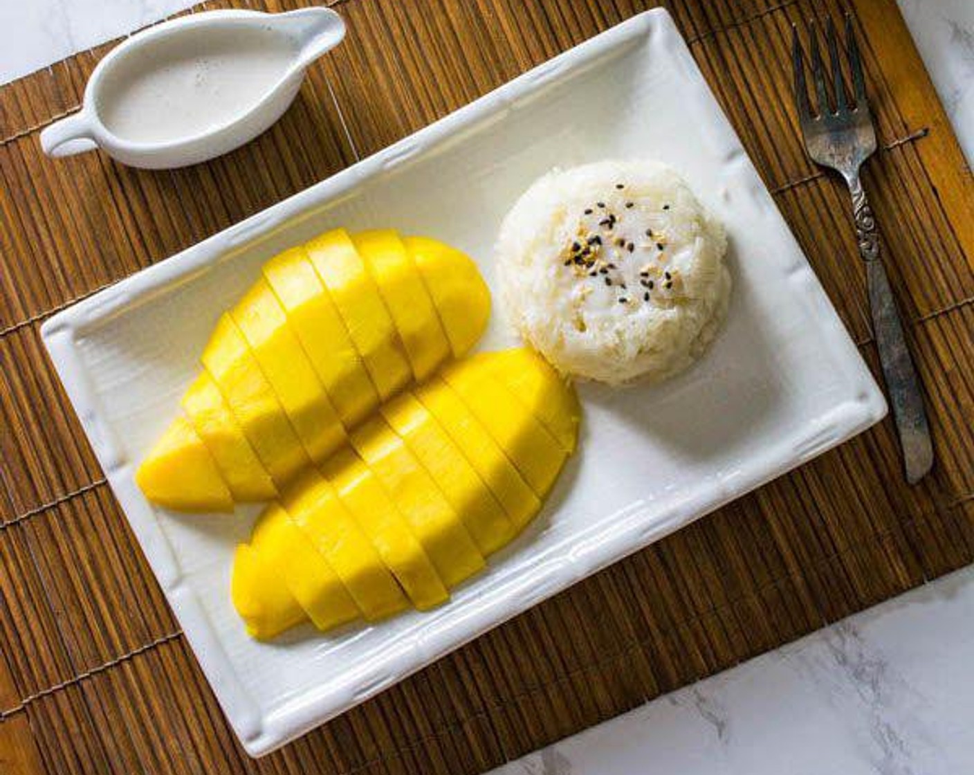 step 5 Serve the Mangoes (4) and the sticky rice together. Garnish with Sesame Seeds (to taste). Drizzle the additional coconut milk onto the rice or mango if desired. Enjoy!