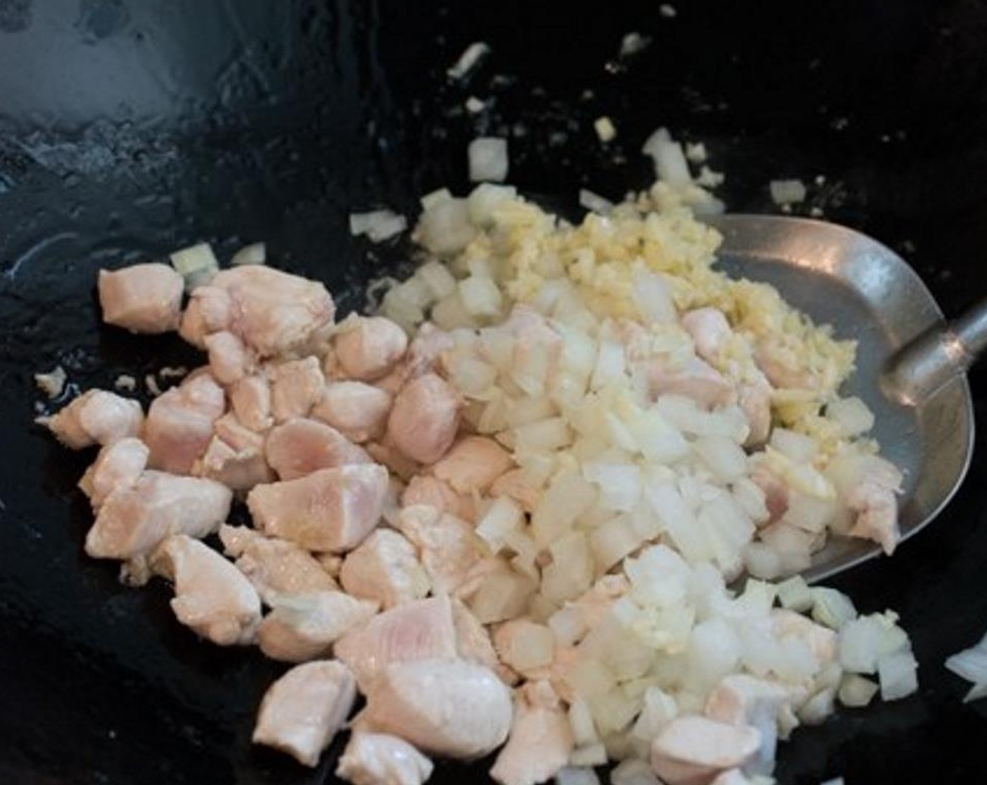 step 6 When the chicken starts to turn white around the edges, toss in Onion (1/2) and Garlic (3 cloves).