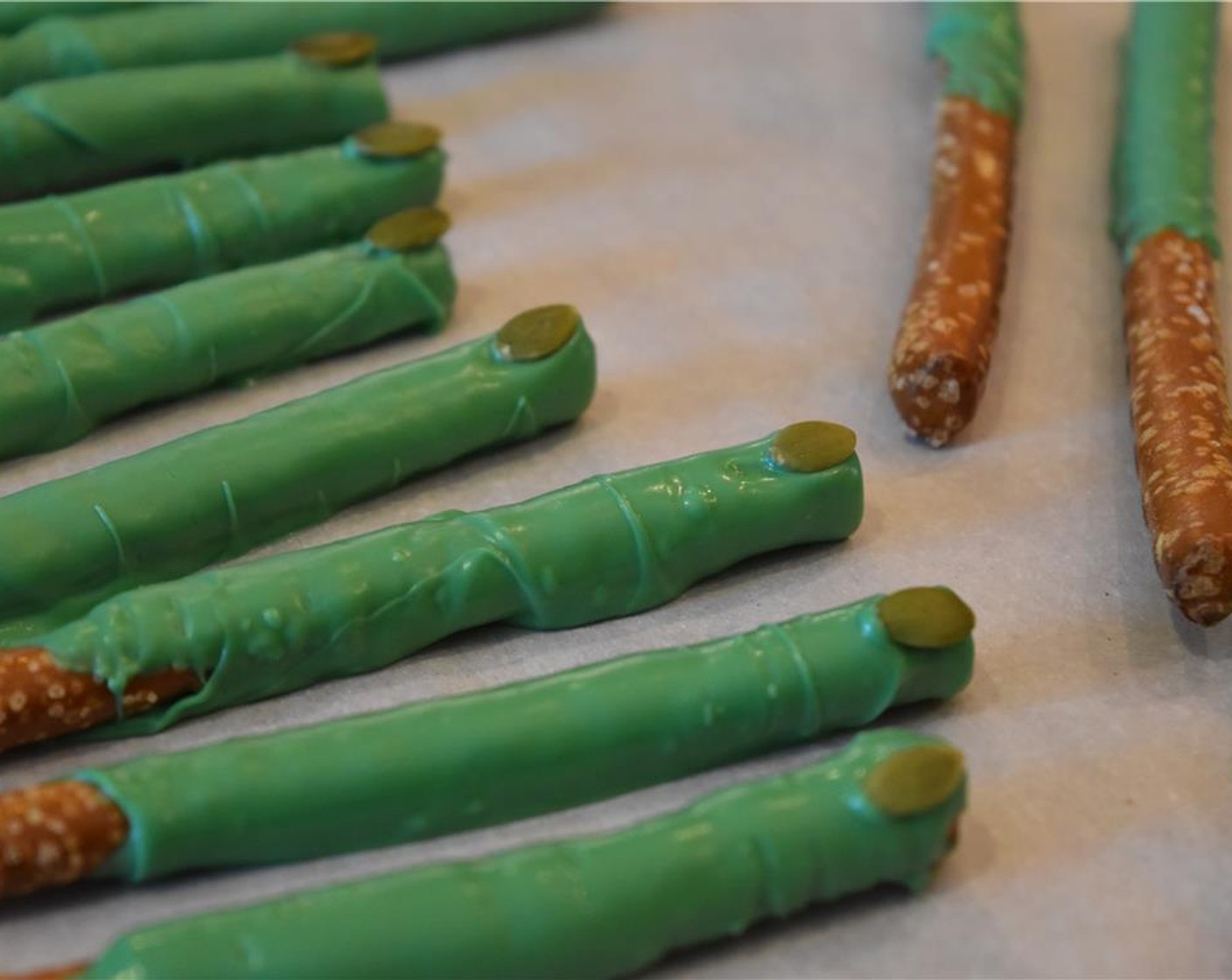 step 3 Roll Pretzel Sticks (24) in the chocolate. Transfer each as you go to a new sheet lined with wax or parchment paper and secure Pepitas (1/4 cup) on the tip to look like a fingernail.