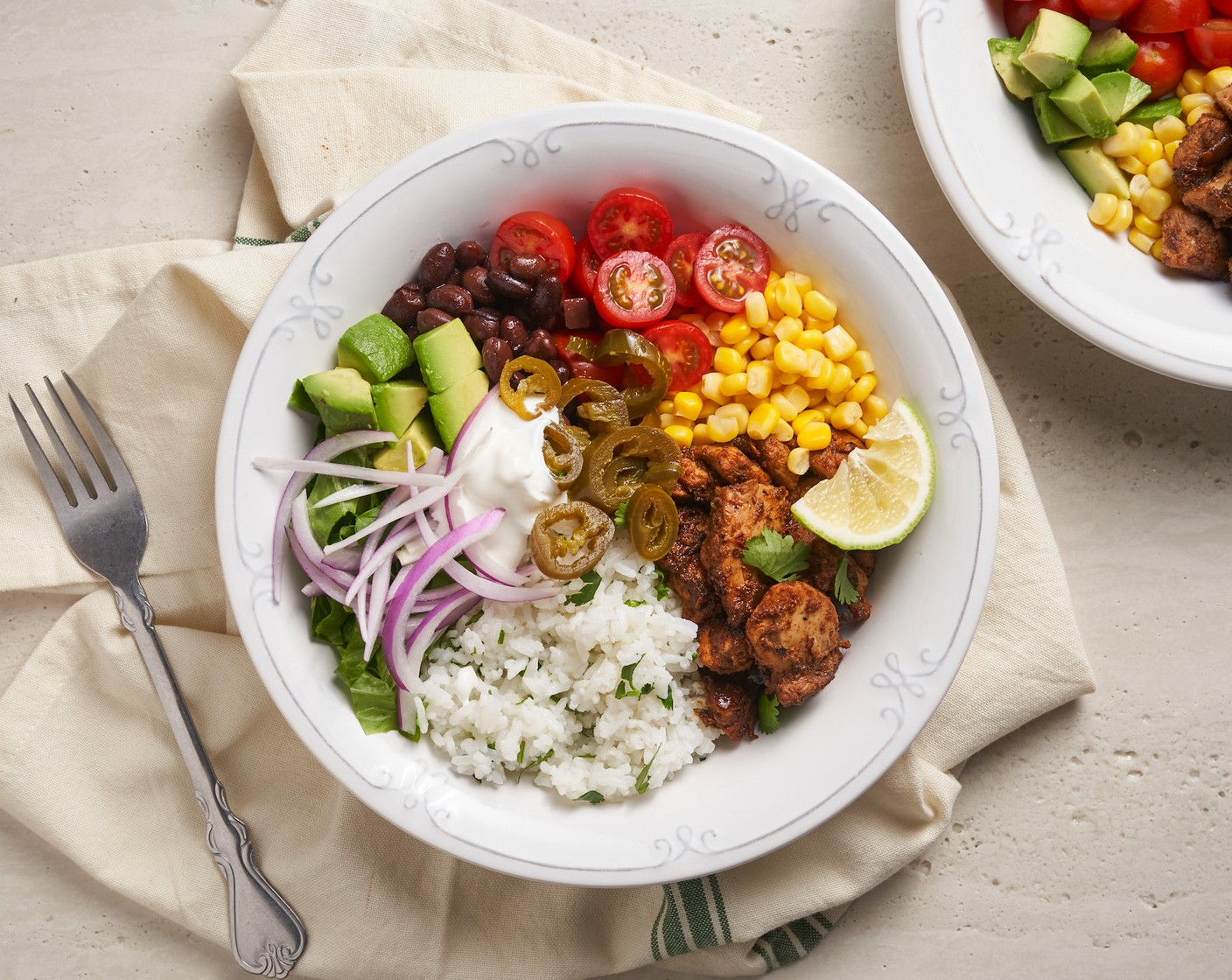 step 5 In a serving bowl, add the rice mixture, then top with chicken, Black Beans (1 can), Diced Tomatoes (1 can), Lettuce (1 head), Red Onion (1), Avocados (3), Whole Kernel Corn (1 can), Fresh Cilantro (1/2 bunch), Sour Cream (1 cup), Pickled Jalapeño Pepper (1 cup). and Lime (1). Serve immediately!