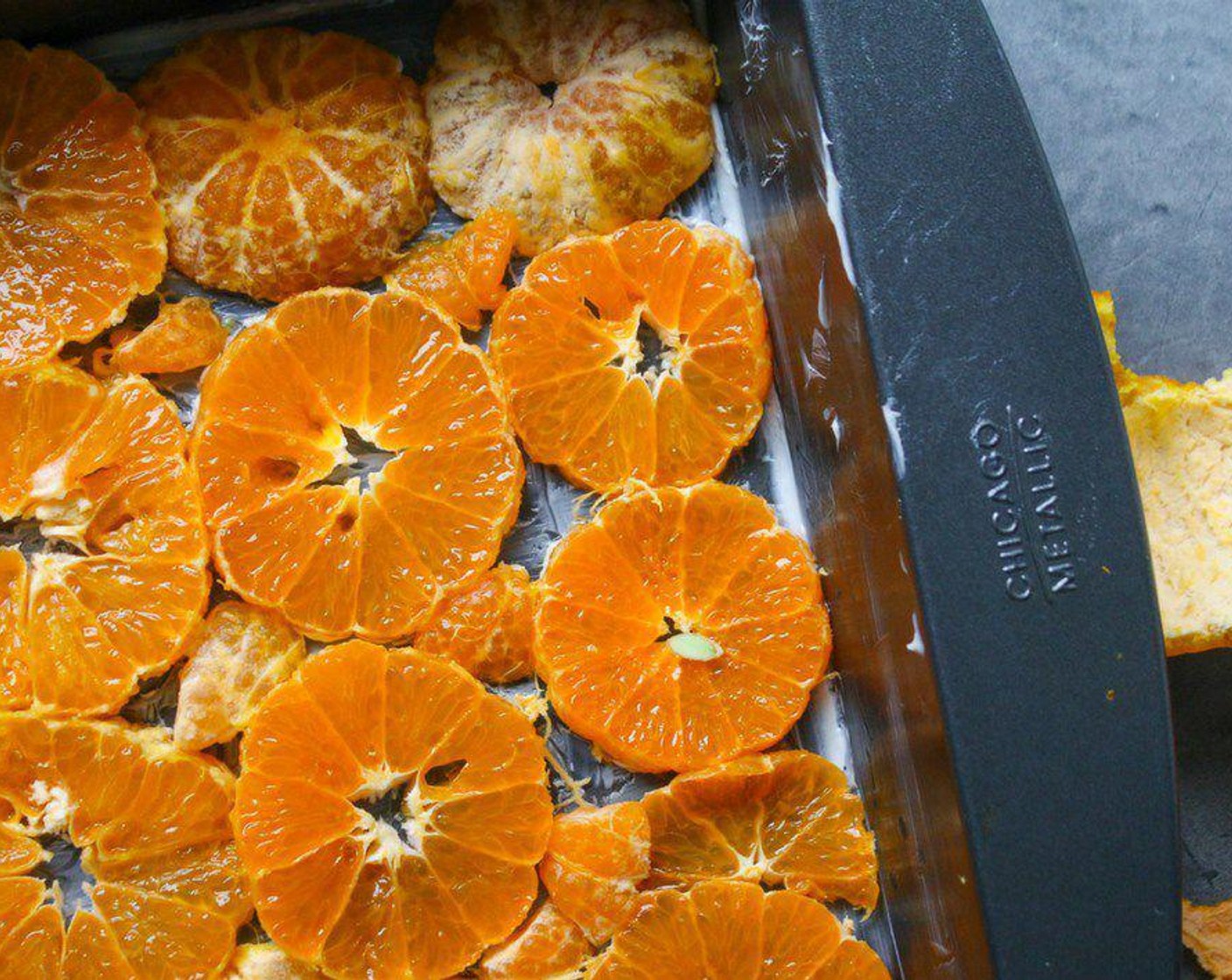 step 2 Zest the Oranges (4) until you have 1 1/2 tablespoons of orange zest. Then peel and slice all the oranges into 1/4-inch thick slices. Place the slices onto the bottom of the greased 9x13 pan in a single layer. You want as little open space as possible. Set aside.