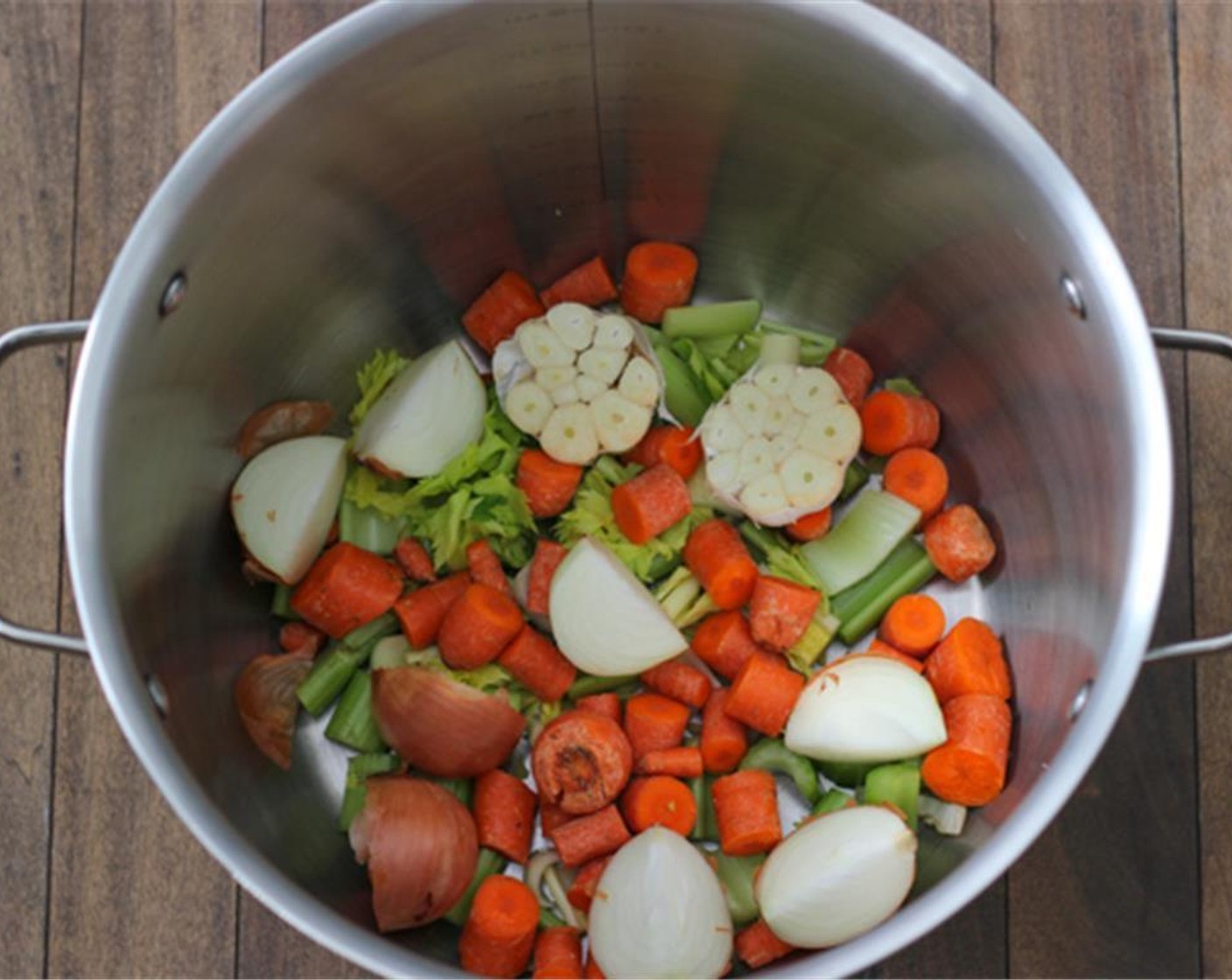 step 2 Cut Onions (2) into quarters and place them in a 16 quart stockpot with the onion peels. The peels help to give a nice brown color to the stock. Coarsely chop the carrots and celery, cut the  Garlic (1 bulb) in half and place them all in the stockpot.