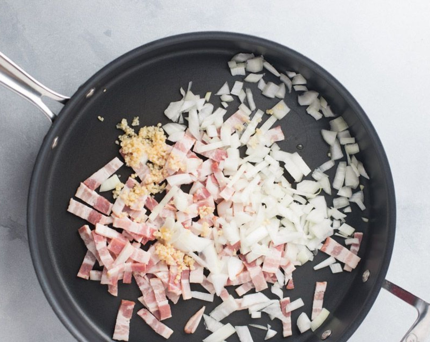 step 3 In an extra-large saucepan add the Bacon (4 slices), Yellow Onion (1 cup) and Garlic (1 Tbsp). Saute at medium to medium-high heat until the bacon starts to brown, about 10 minutes, stirring occasionally.