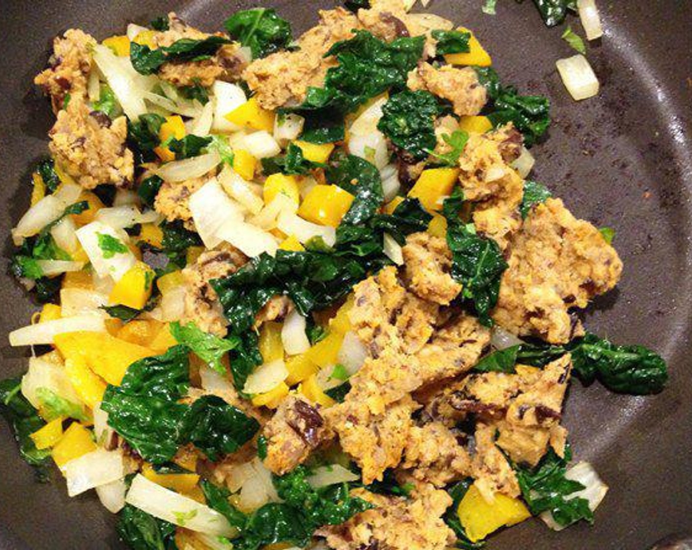 step 4 Mean while, add Onion (1/2 cup) and Bell Pepper (1/2 cup) pan and saute until onions are soft and transparent, add in Kale (1 1/2 cups) and cook until tender. Take the "veggie patties" and cut into small squares, add to onions and peppers and cook until heated through.