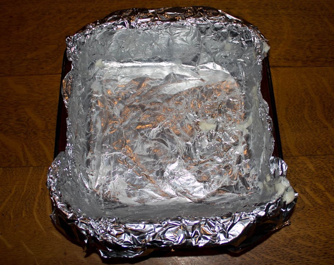 step 1 Preheat the oven to 350 degrees F (180 degrees C). Line an 8-inch square baking pan with aluminum foil and grease foil with either butter or vegetable shortening.