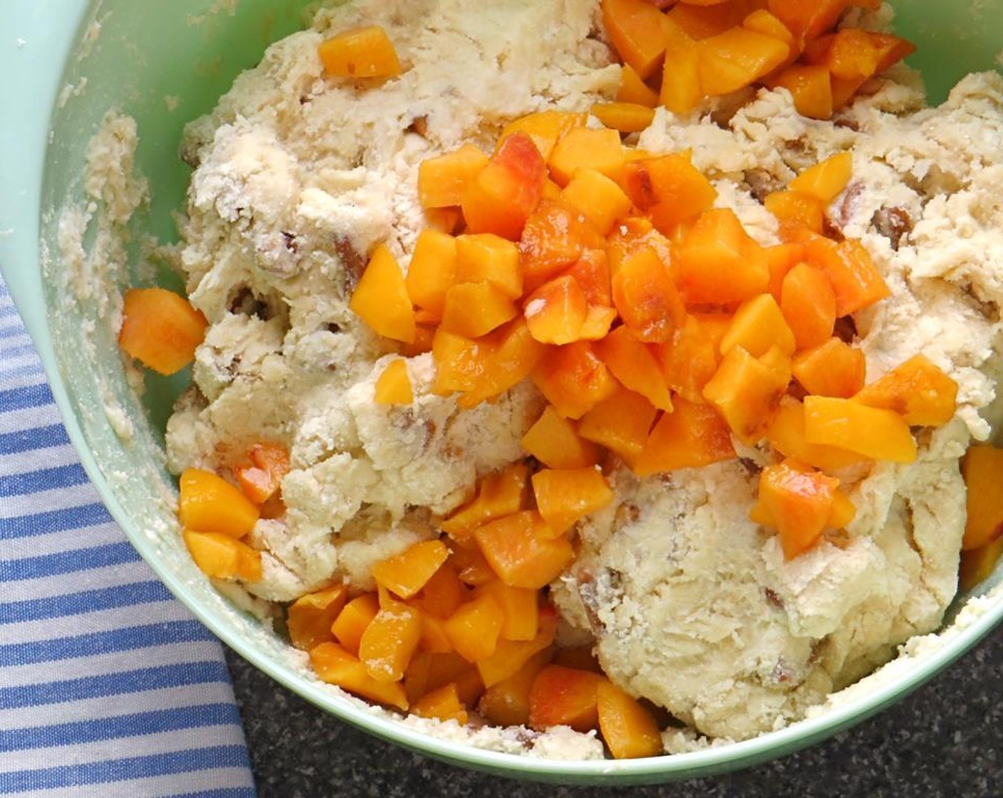 step 12 Add the peaches and fold the dough over the fruit several times until the peaches and pralines are evenly distributed throughout the dough. Be careful not to overwork the dough.