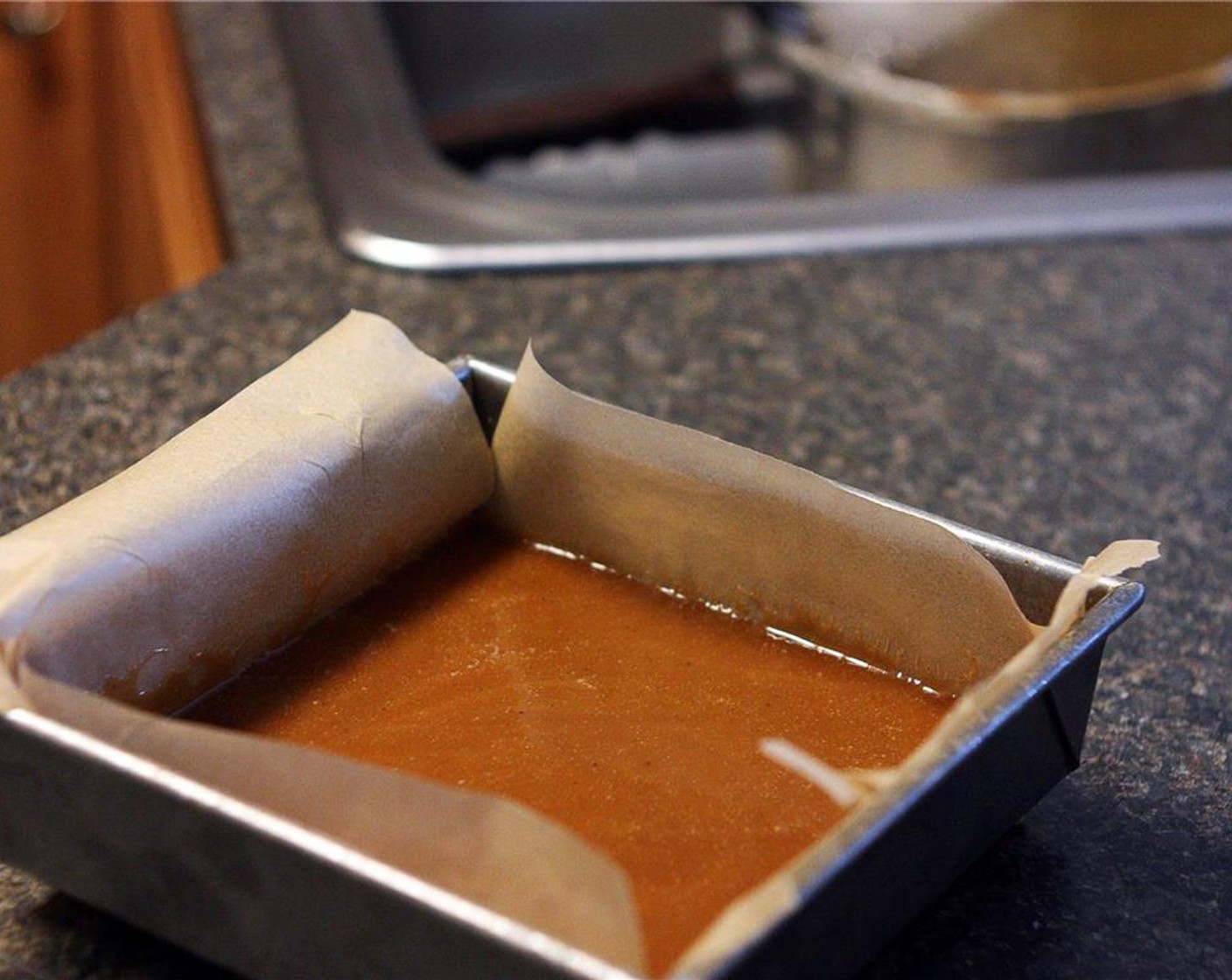 step 6 Remove the thermometer and place it in the sink, and pour the caramel into the parchment lined square pan. Allow the caramel to cool until it is room temperature and firm. This will take about two hours.