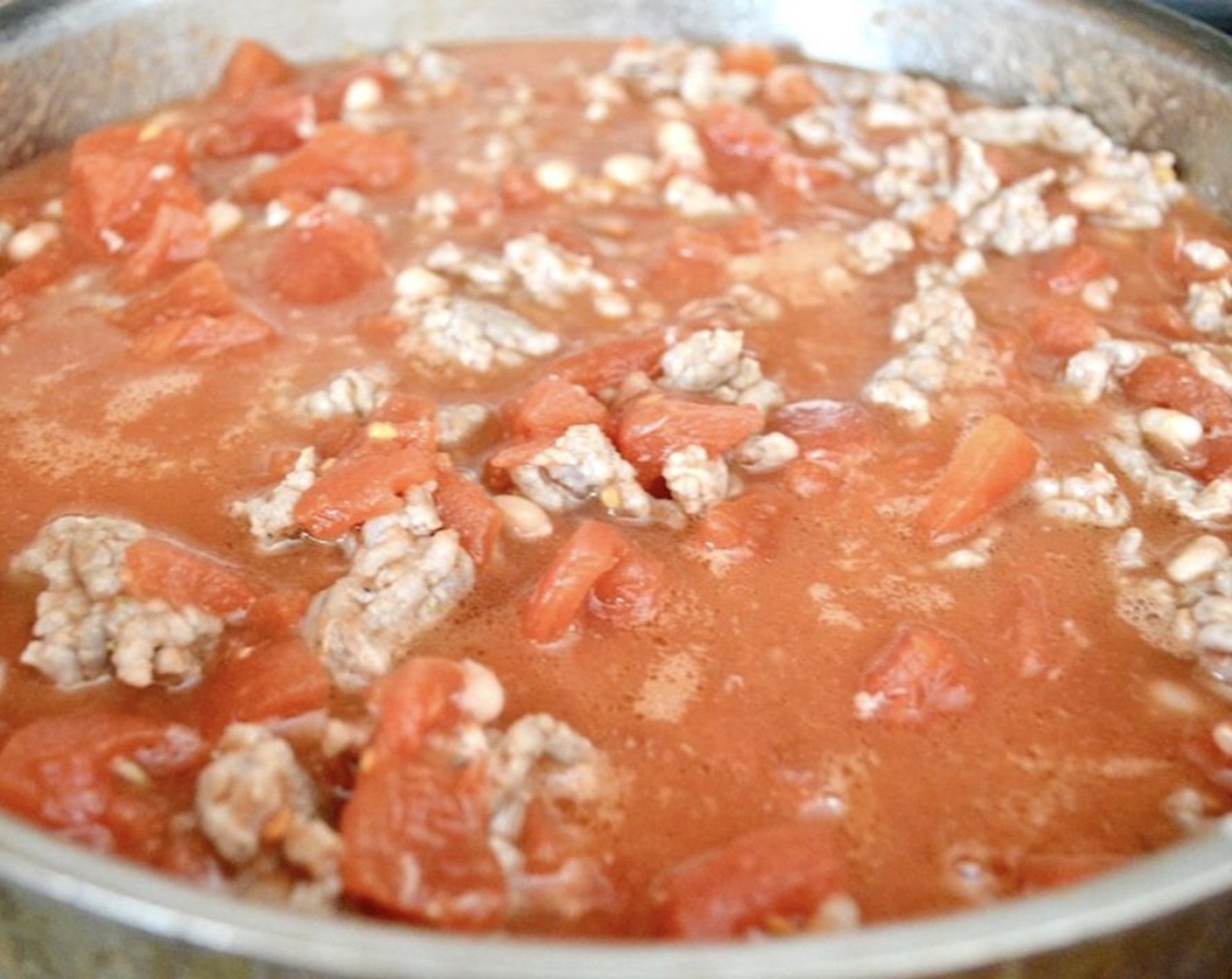 step 4 Add the sausage back in, along with the Diced Tomatoes (2 cans) and Parmesan Cheese (1/2 cup). Season it all generously with the Salt (2 pinches) and Crushed Red Pepper Flakes (2 pinches) and give it a good stir. Let the sauce simmer for 10 minutes.
