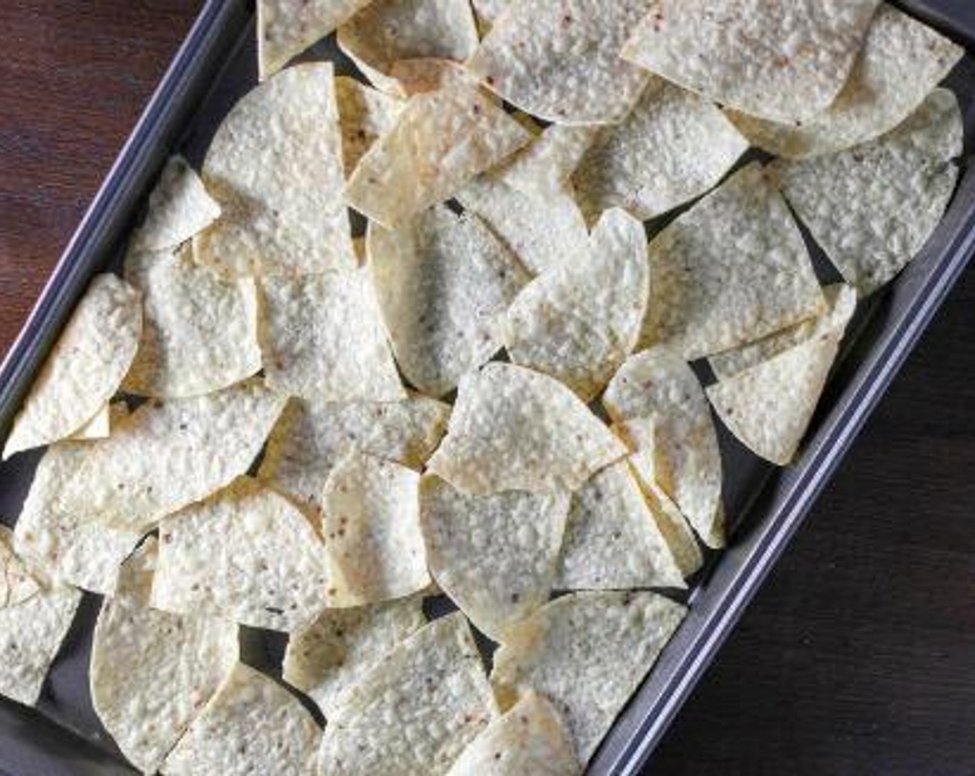 step 1 On a large baking sheet, spread the Restaurant Style Tortilla Chips (10 cups) out in an even layer as best as you can. Cover the chips with Refried Beans (1 3/4 cups), Canned Black Beans (2 1/3 cups) and Canned Sweet Corn (2 2/3 cups).