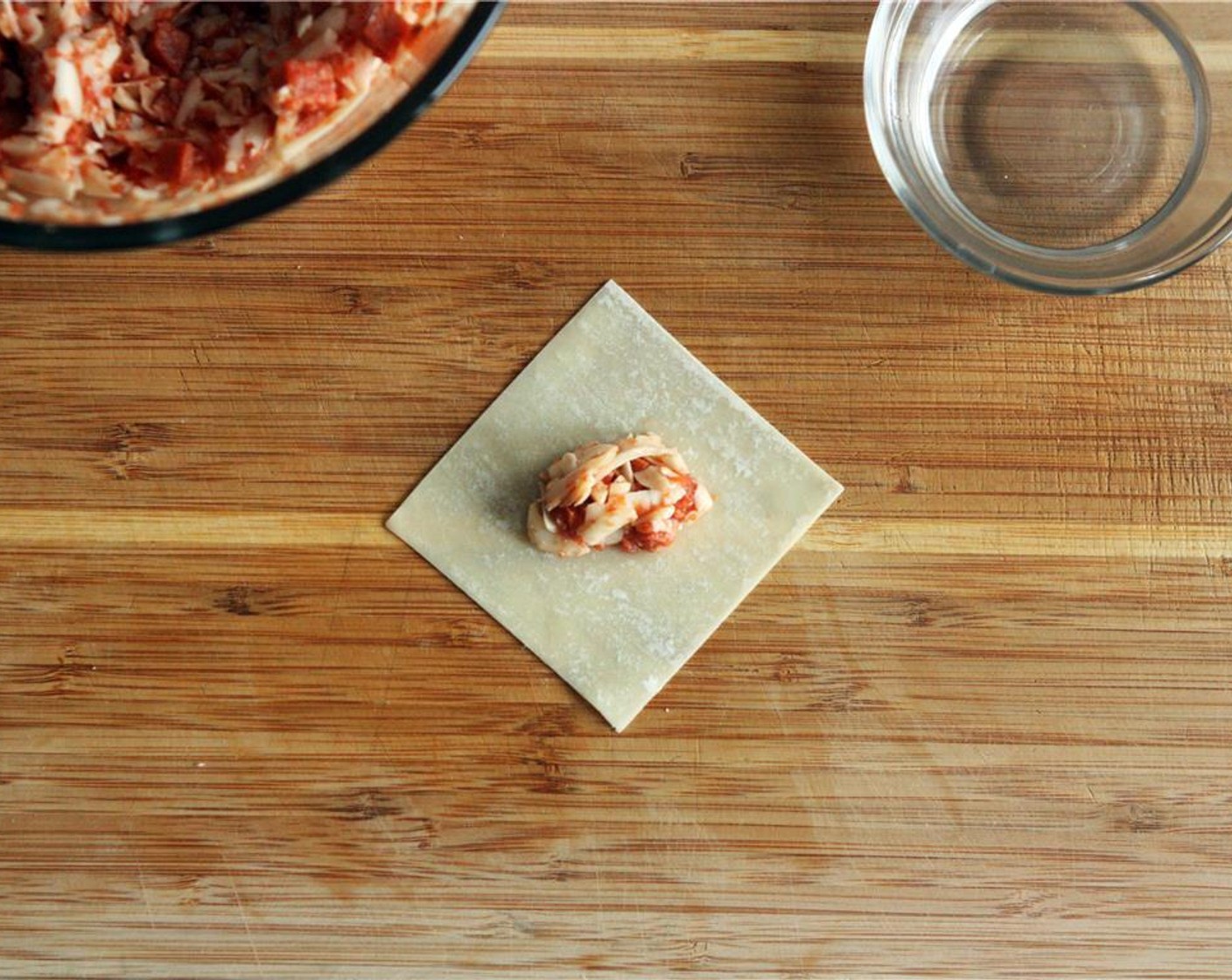 step 3 Working one wrapper at a time, place 2-3 teaspoons of the mixture in the center of a Wonton Wrappers (50). Dip your finger in water and run it along all four edges of the wrapper.