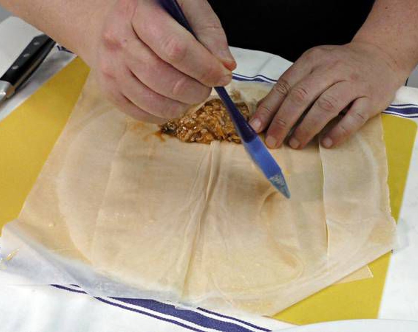 step 13 Brush the area surrounding the chicken mixture with egg wash and roll tightly until closed.