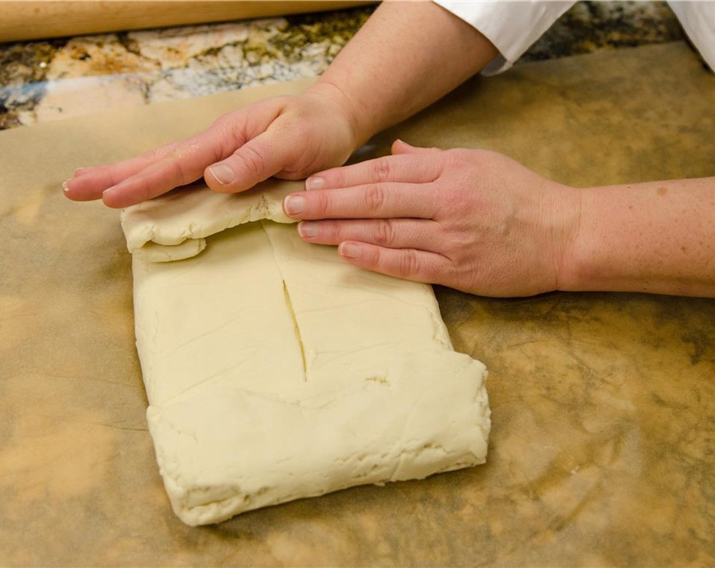 step 9 Then fold in the sides. Place the butter-filled dough in between two clean pieces of plastic wrap or parchment paper.