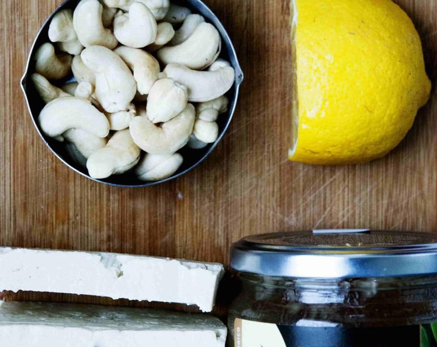 step 2 Place the Silken Tofu (7 oz) into cheesecloth and squeeze out all the water. Then put it in a blender or food processor together with the Honey (1 Tbsp), cashew nuts, Lemon (1), and Vanilla Extract (1/2 tsp).