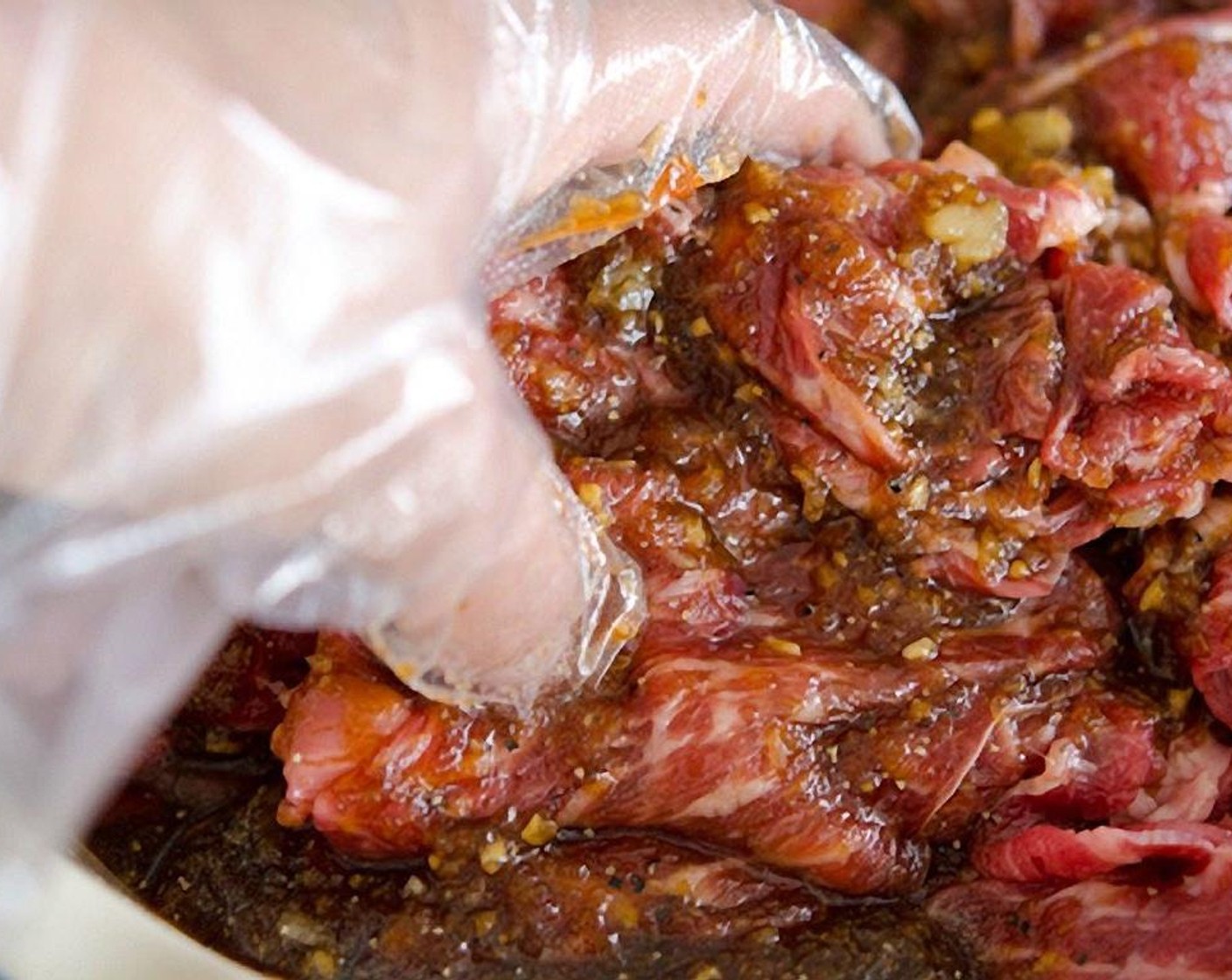 step 7 Place the beef in a large mixing bowl, pour the sauce, and mix well with your hand. Let it sit for 15 minutes for the meat to soak up the flavor.