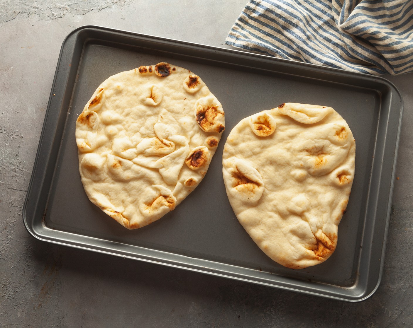 step 2 Place 2 pieces of Naans (4) on each baking sheet and spray with Nonstick Cooking Spray (as needed).