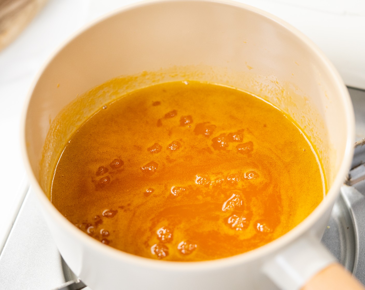 step 11 While the cheesecake is in the fridge, make the cheesecake topping sauce. In a saucepan over medium, add Passion Fruit Pulp (1/2 cup), Mango Juice (2 Tbsp), 1 Tbsp of Lime Juice (1), and Granulated Sugar (1/3 cup). Simmer for about 15 minutes until it starts to thicken. Then transfer the topping to a bowl to cool down completely.