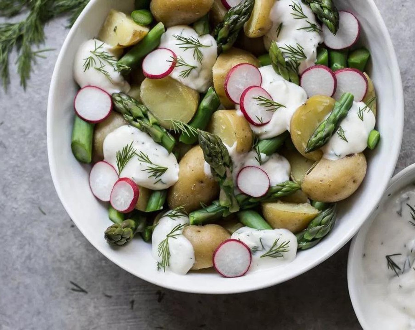 step 5 Once the potatoes have cooled to room temperature, add the potatoes, asparagus and Radish (1 bunch) to a large bowl in layers so they are evenly distributed, also adding dollops of the dressing as you layer your vegetables. Finish the top of the potato salad with dollops of the remaining dressing, asparagus pieces, sliced radishes and a sprinkle of fresh chopped dill for garnish. Serve chilled or at room temperature.