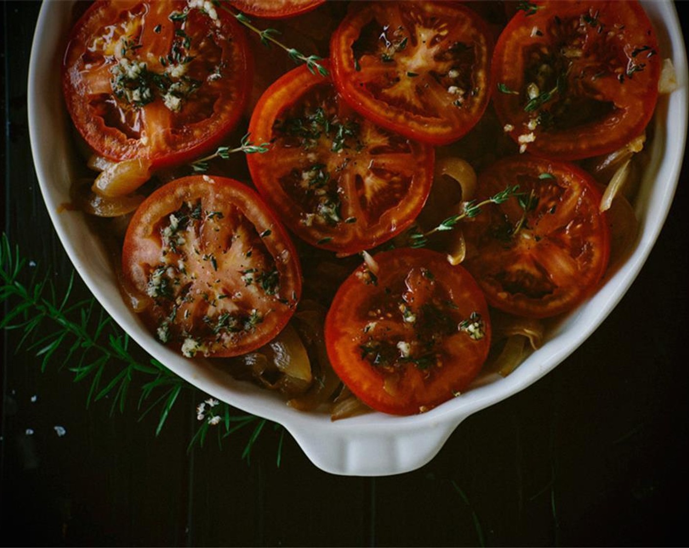 step 11 Slightly overlap tomato slices in a single layer on top of the onions. Spoon the rest of the olive oil mixture evenly over tomatoes.