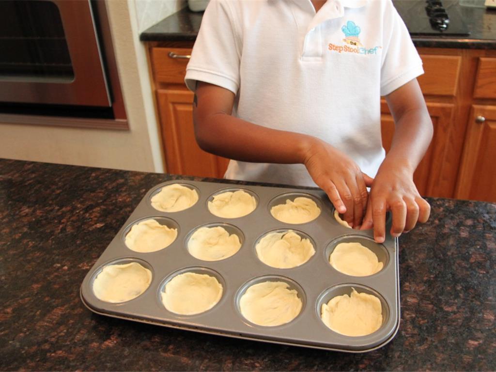 Step 1 of Muffin Tin Pot Pie Recipe: Preheat the oven to 375 degrees F (190 degrees C). Lay your Crescent Dough Sheet (1 package) flat then use a 3-inch cookie cutter to make round shapes. Lay the round dough shapes in the muffin pan and press along the bottom & sides.
