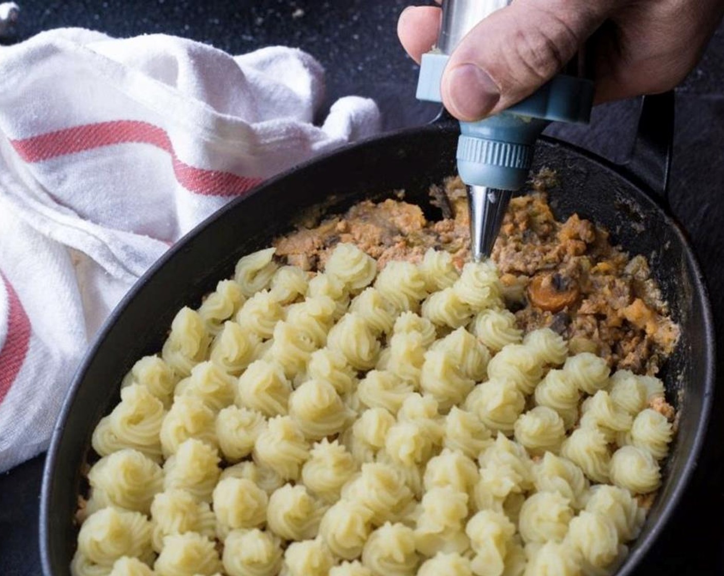 step 11 Meanwhile, spoon the meat mixture into a shallow baking dish or casserole and spread mashed yams overtop. Place the baking dish onto baking sheet to catch any spillover from the juices.