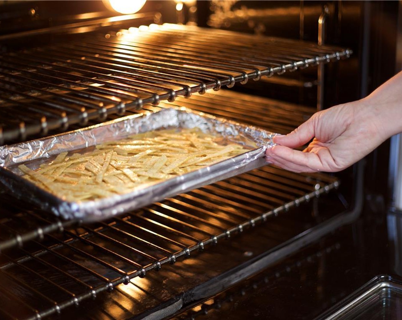 step 13 Line baking sheet with foil and place tortilla strips in a single layer. Bake for 5 minutes.
