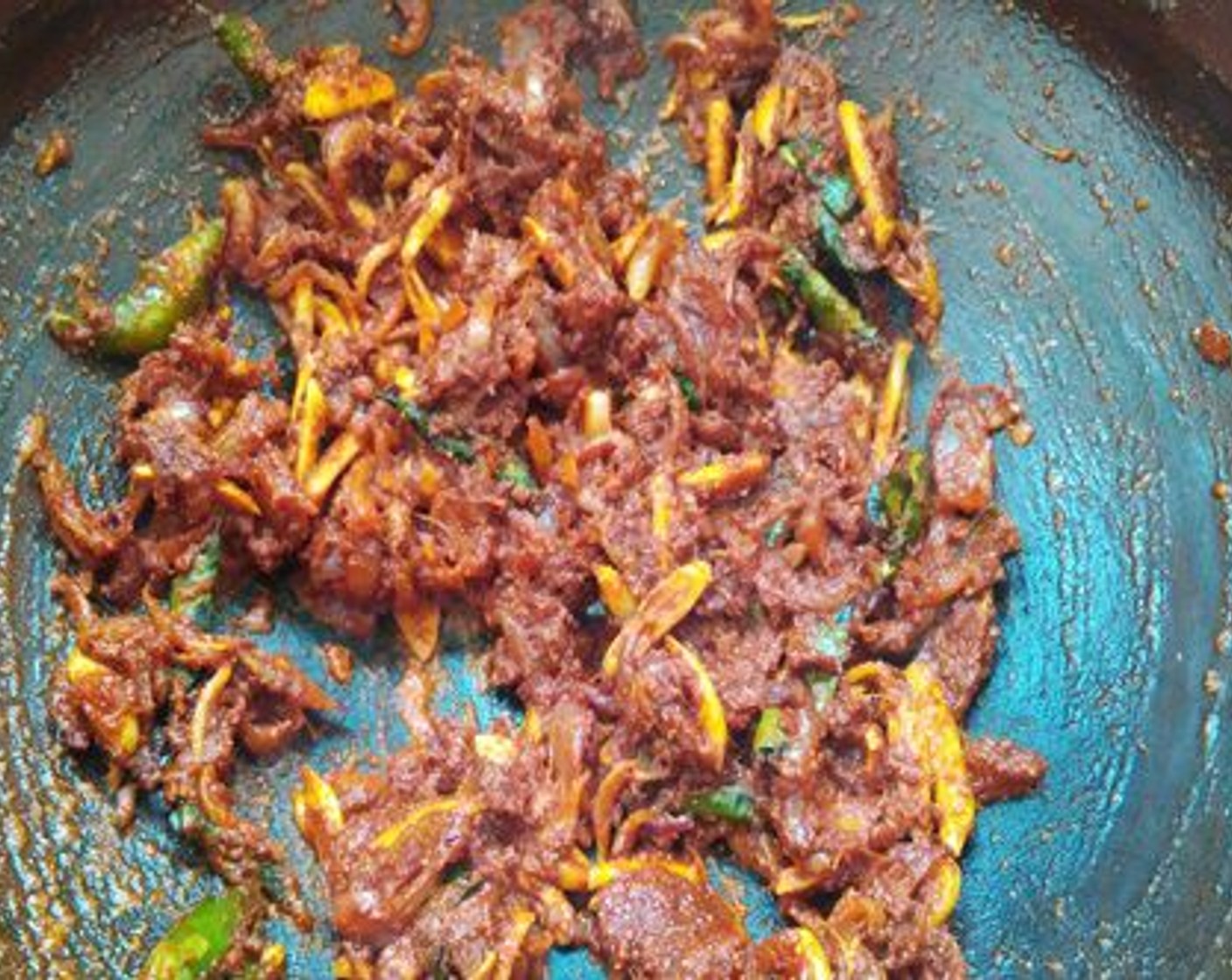 step 5 Reduce the flame add Red Chili Powder (2 Tbsp), Ground Turmeric (1/2 tsp) and Ground Coriander (1 tsp). Add kudampuli along with the water.  Add more water if required but not too much. Let it boil well and then add cleaned prawns. Cover and cook in low flame for ten minutes.