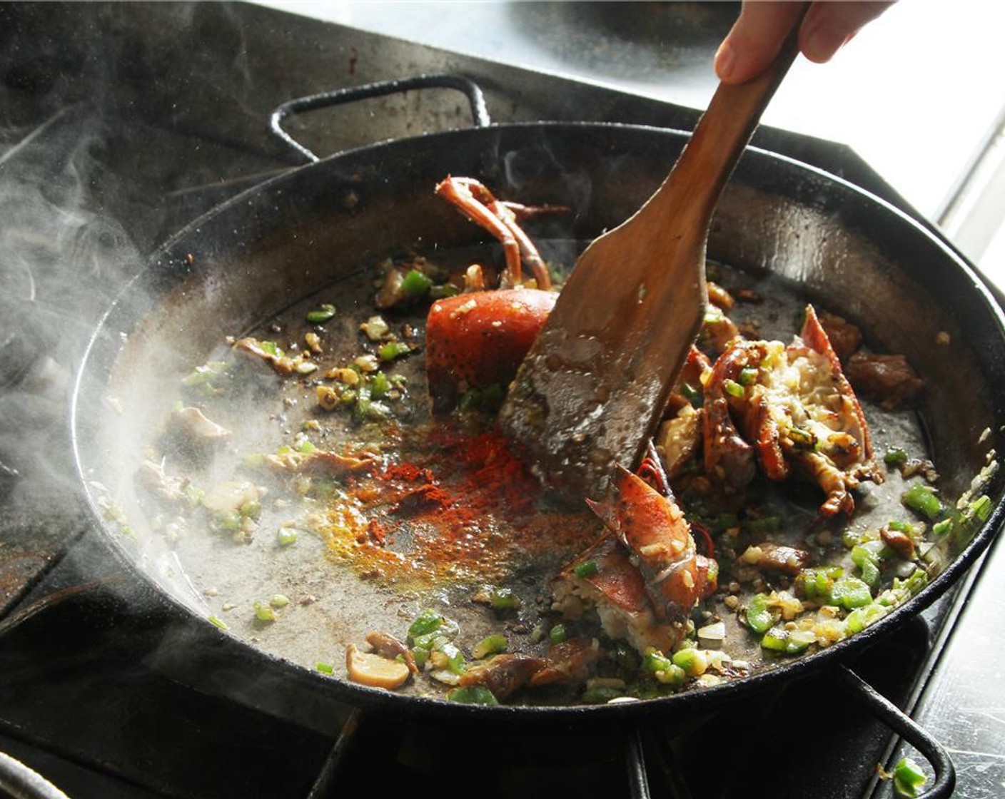 step 13 Make a small pocket in the middle of the pan. Add Olive Oil (1 Tbsp) and Spanish Smoked Sweet Paprika (1 1/4 tsp). Cook the smoked paprika for a few seconds.