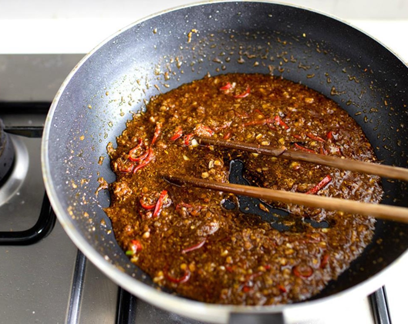 step 21 Add Canola Oil (1/4 cup) to the same skillet until hot, then add the seasonings from the second bowl. Cook until fragrant without burning the garlic, then add the third bowl. Turn off the heat while you cook the noodles.