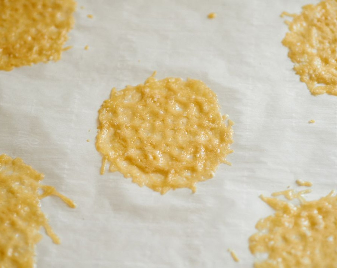 step 4 Bake for 3-5 minutes until cheese is bubbling and beginning to crisp. Remove from oven and allow them to cool completely before lifting off the parchment.