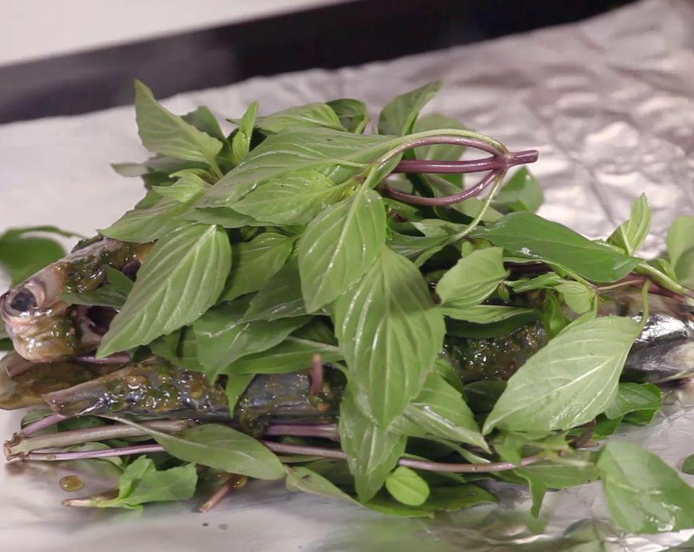 step 4 Spread Fresh Basil (5 cups) on aluminum foil, then put fish on top of the basil bedding. Pour the leftover sauce over the fish. Cover the fish with another layer of basil, then wrap the foil.