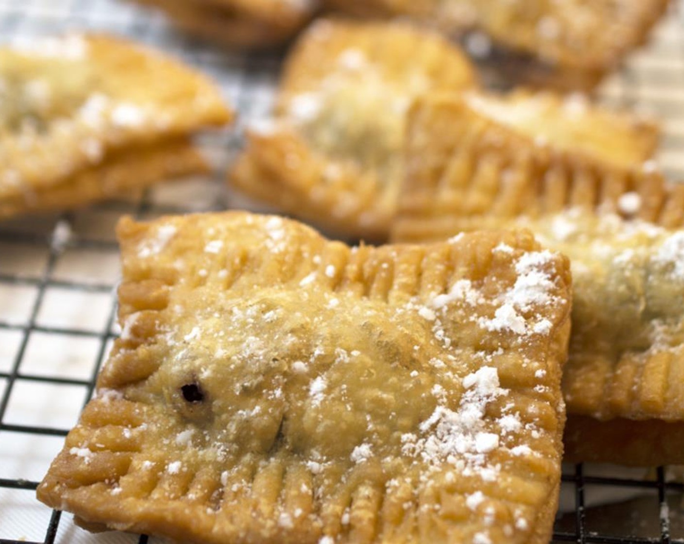 step 9 Place on a plate lined with paper towels to soak up any excess oil. Allow to cool for a minute. Sprinkle with Powdered Confectioners Sugar (to taste) and serve immediately.