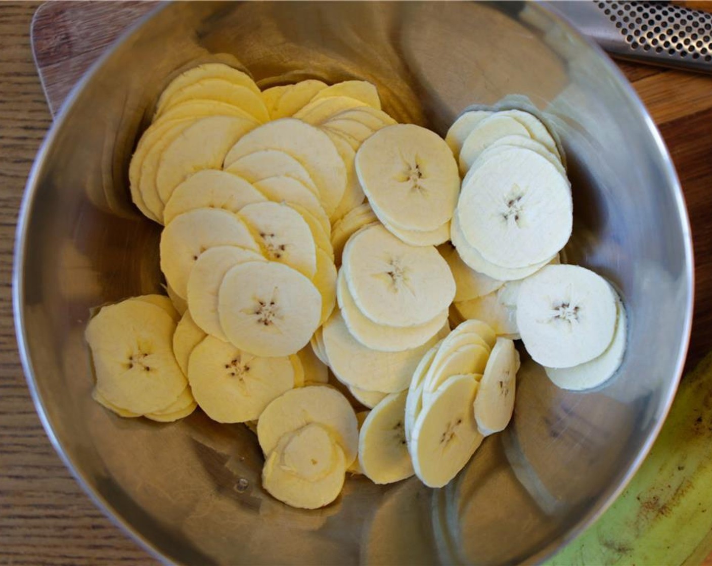 step 6 Place the sliced plantain in a bowl with the Coconut Oil (3 Tbsp), Salt (1/2 tsp) and Freshly Ground Black Pepper (1/4 tsp). Use your hands to separate the slices and ensure they are evenly coated.