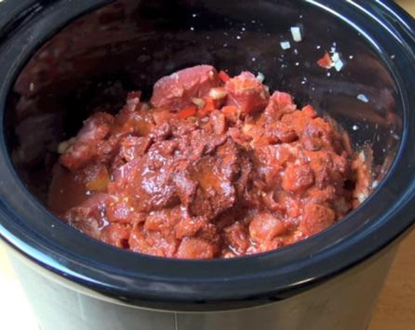 step 1 Into a slow cooker, add the Beef (2.2 lb), Beef Stock (1/2 cup), Yellow Onions (2), Garlic (1 clove), Red Bell Peppers (2), Canned Diced Tomatoes (1 3/4 cups), Sweet Paprika (2 Tbsp), Water (1/2 cup), Salt (to taste) and Ground Black Pepper (to taste). Mix everything together, and cook for 8 hours on low.