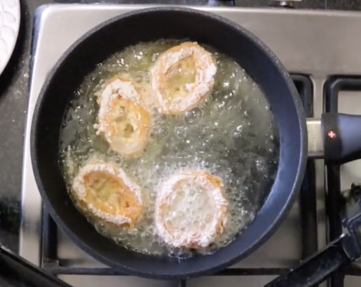 step 6 Heat a fry pan over medium-high heat and add Sunflower Oil (1/2 cup). Once the oil gets very hot, after 3 to 4 minutes, start adding the squid rings. Cook in batches to not over-crowd the pan. Fry the rings for 1 minute per side, then transfer to a plate with paper towels as you finish each batch.