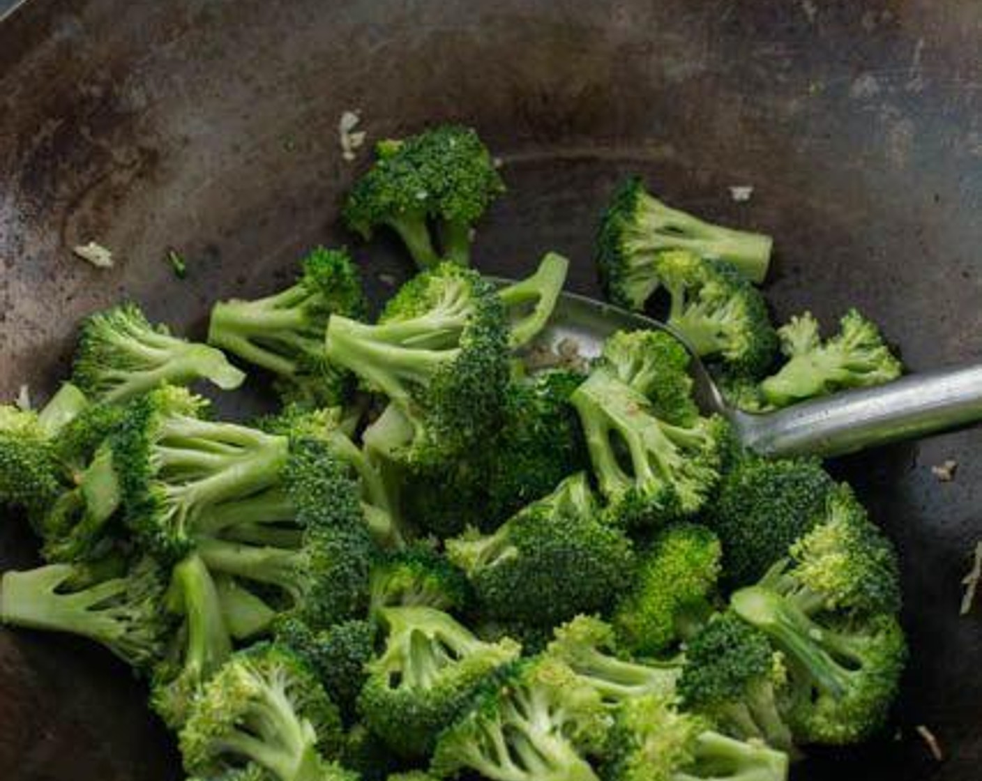 step 5 Add Cooking Oil (1 Tbsp) to the wok, then add the Garlic (2 cloves). Stir-fry for just a few seconds, then add the Broccoli Florets (6 cups). Stir-fry for about a minute.