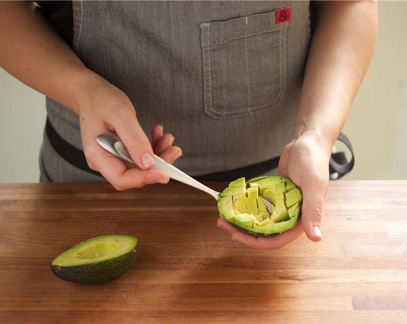 step 6 Cut the Avocado (1) in half around the pit, remove and discard the pit. Using your knife, score avocado flesh without piercing the skin, and scoop out the flesh.