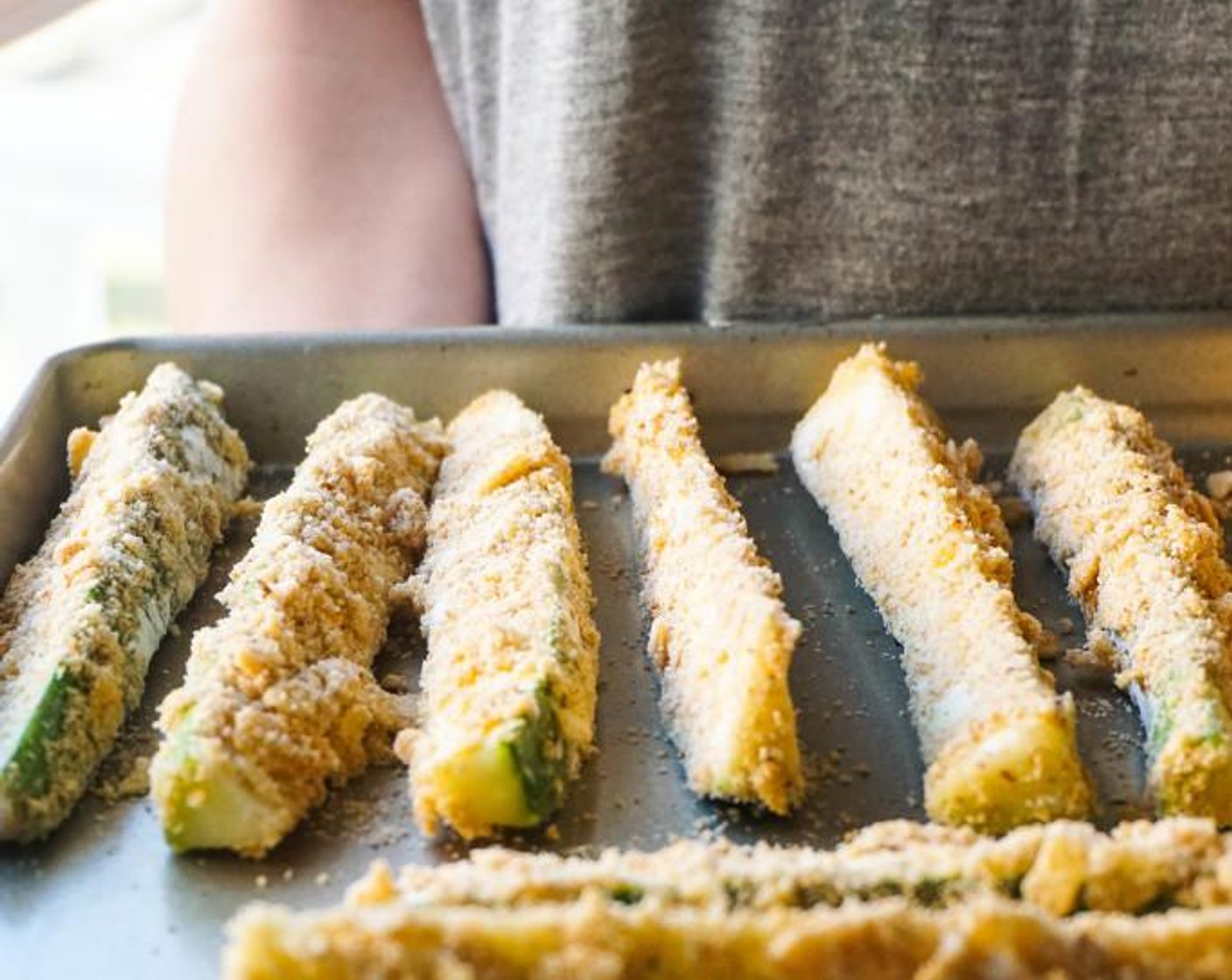 step 5 Dip the zucchini fries in the order mentioned above and transfer to a baking sheet. Repeat until all fries are coated.