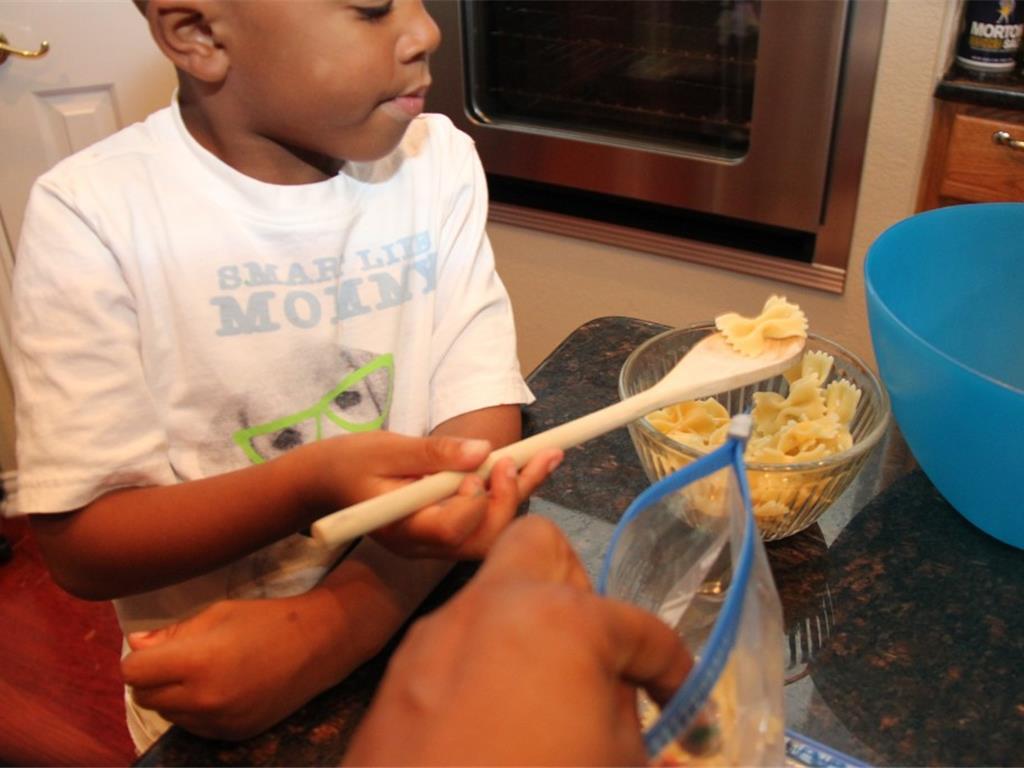 Step 5 of Rainbow Pasta Salad Recipe: Transfer the pasta in even portions to the prepared zip top bags and seal. Shake zipper bag to combine the pasta and food coloring, and then let each bag sit for at least 1 minute to soak up the color.