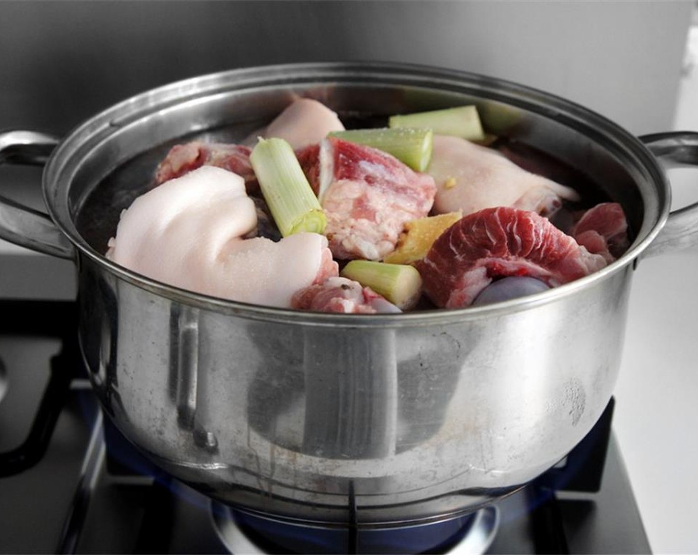 step 2 Place the Whole Chicken (1), Pork Backbone (4 pieces) and the trotter in a large pot with a few pieces of Scallions (to taste) and Fresh Ginger (to taste).