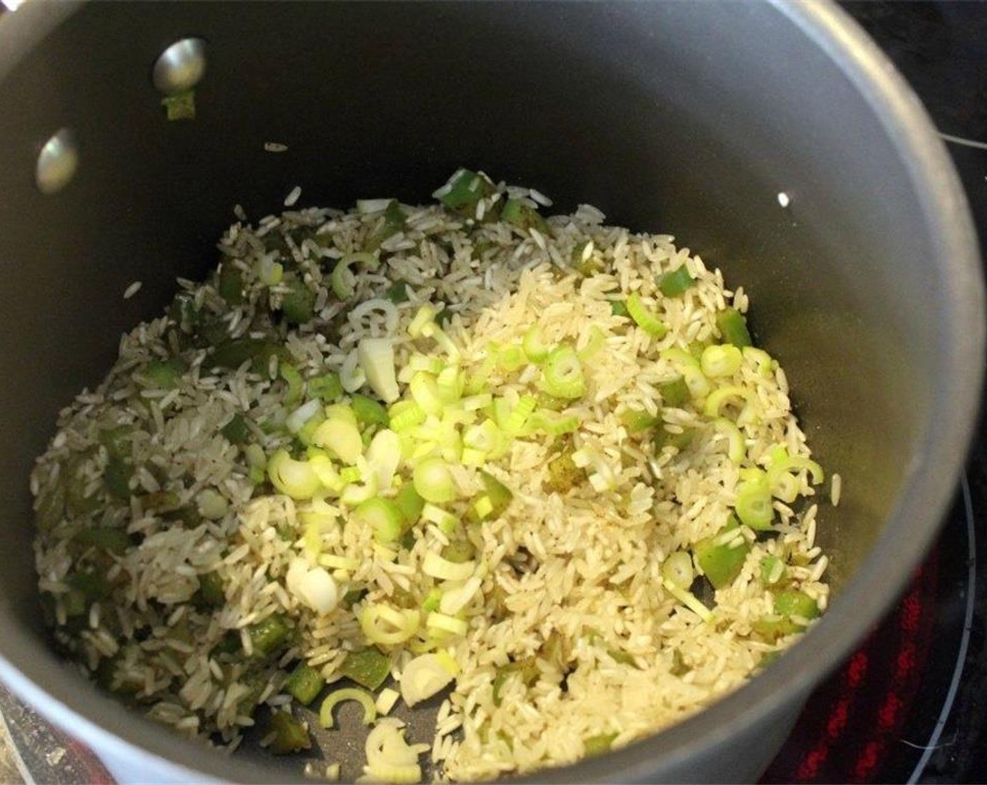 step 6 Stir the rice with the green pepper for a minute to coat it in the oil, then toss in the white parts of the scallion.