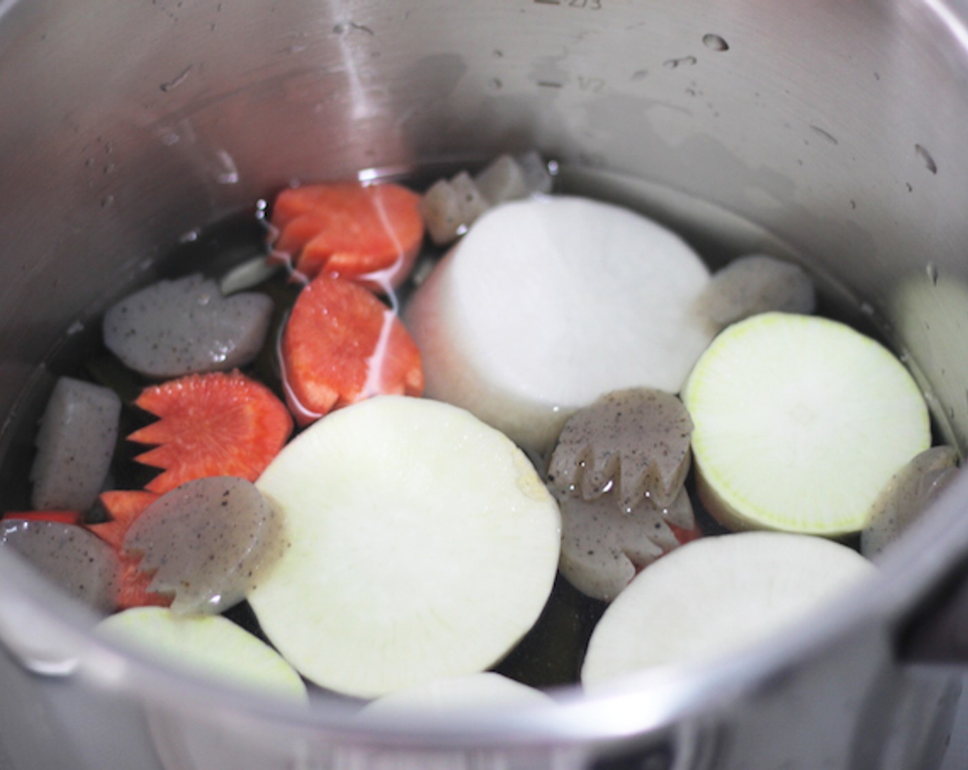 step 7 Put the kombu, Daikon Radish (1), carrot, and konjac in a pot with water and put it on medium heat until it starts boiling. at which point you lower the heat.