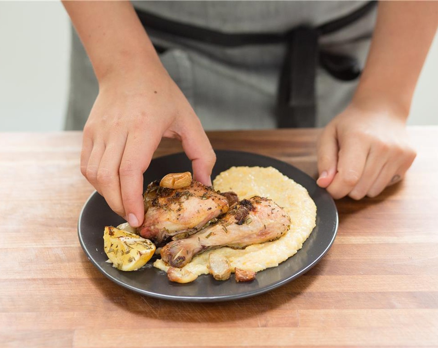 step 12 In the center of two plates, place the cheese grits. Top with the roasted garlic chicken.