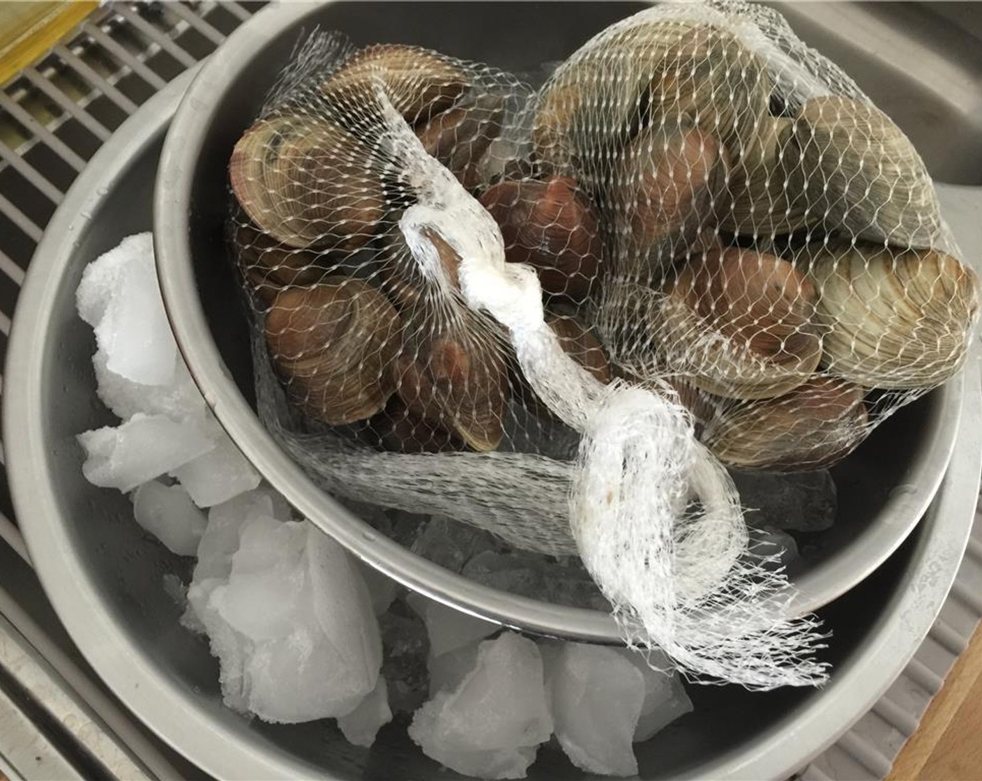 step 2 Place a medium-size bowl inside a larger bowl filled with ice. In that bowl, place the Littleneck Clams (3 lb). This will keep the clams cold as you clean them.