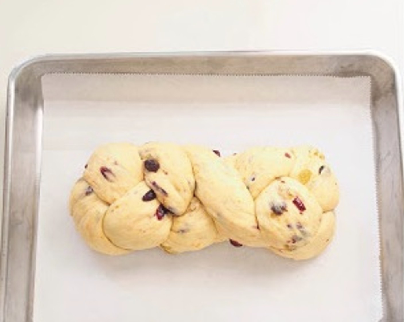 step 9 Punch down the dough to release the air. Transfer the dough to a clean floured surface then divide into 3 equal portions. Form each portion into a strand about 12 inches long. Braid the dough strands, pinch the end and tuck both ends under the bread. Transfer the bread onto baking trays lined with parchment paper.