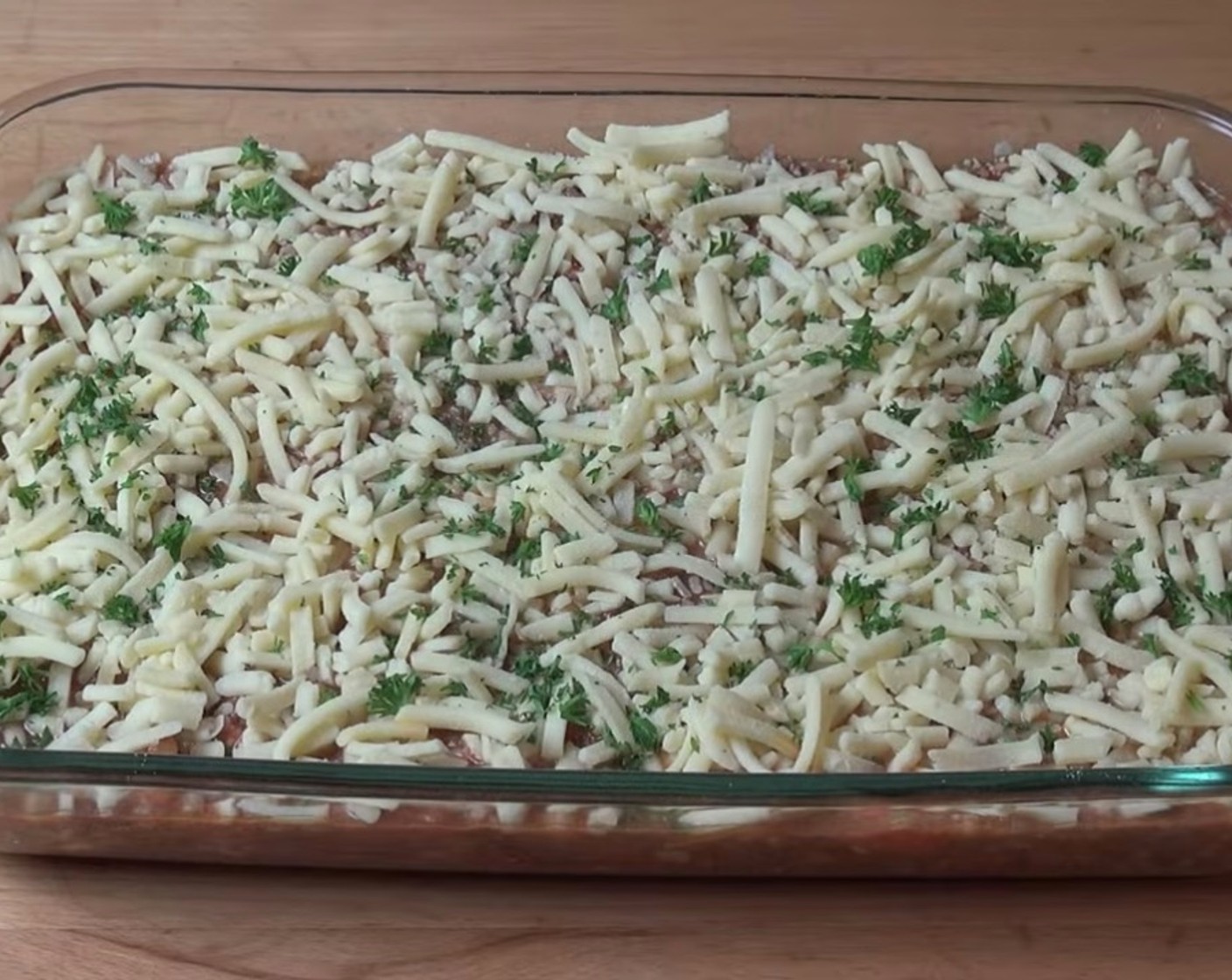 step 7 Mix in the cooled bolognese sauce. Transfer the mixture to a large baking dish and top with cheese and parsley.