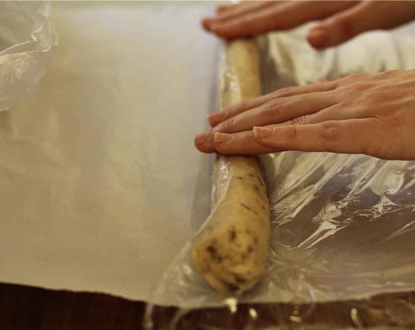 step 11 Place a piece of plastic wrap at the bottom of the board and roll the log onto the plastic. As it rolls, it will wrap itself in the plastic.