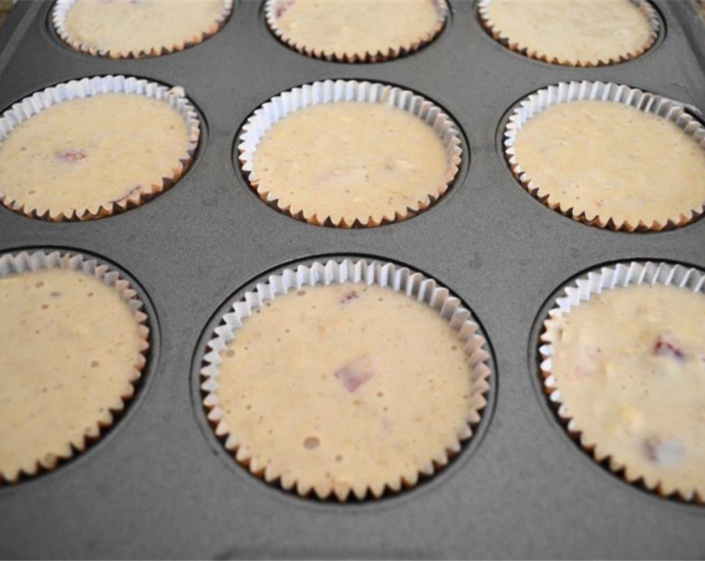 step 6 Scoop a 1/3 cup portion of the batter into each lined well, then bake the muffins for about 30 minutes or so. A toothpick inserted in the center should come out cleanly.