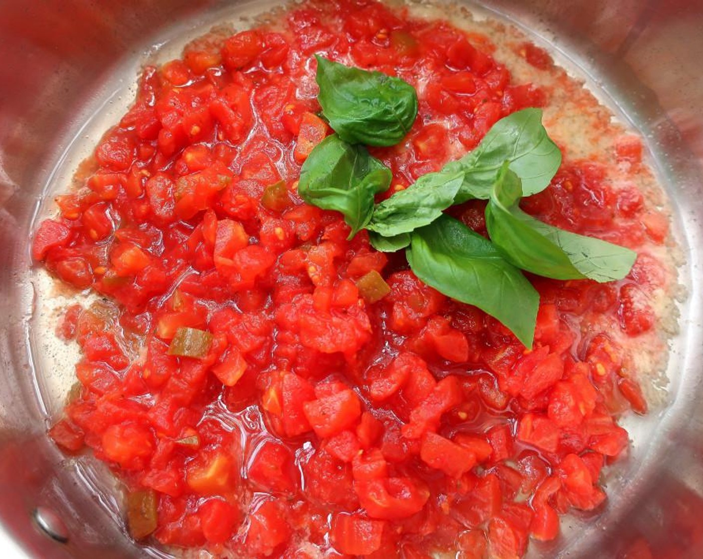 step 4 Add Canned Diced Tomatoes (1 cup) and Fresh Basil Leaves (7). Saute for 1 minute.